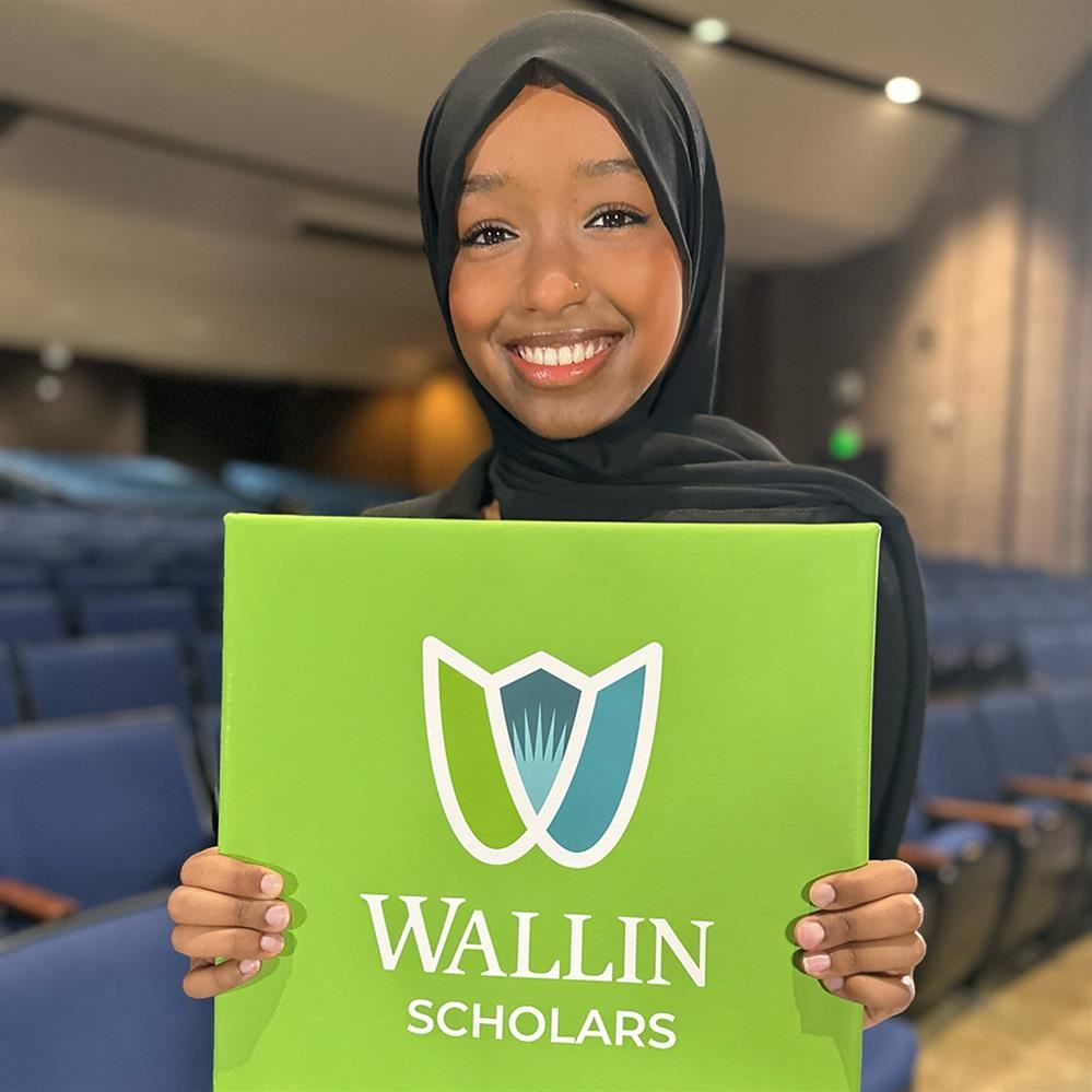  girl holding Wallin Scholars poster